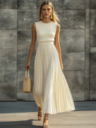 Maxi dress featuring a sleeveless knit bodice and a flowing pleated chiffon hem, designed for women in an elegant cream color. 1