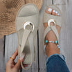White flat sandals for women featuring a stylish metal buckle, designed for comfort and easy slip-on wear, perfect for summer outings. 3
