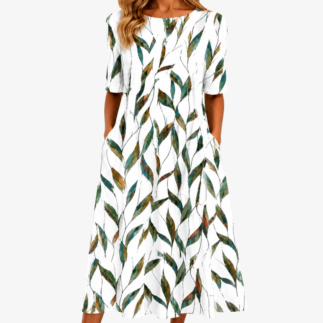 White midi dress featuring a relaxed silhouette, side pockets, and a vibrant botanical leaf print, perfect for women looking for stylish comfort. 0