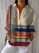Women's long sleeve blouse featuring a button-up front and a stylish geometric color block design in red, blue, and cream. 0