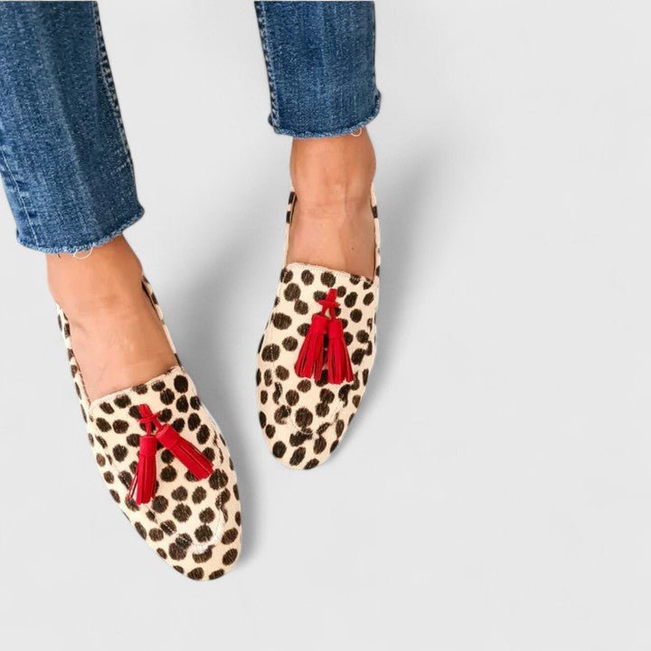 Women's leopard print loafers featuring orthopedic support and a convenient slip-on design, adorned with stylish red tassel accents. 0
