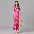 Elegant women's maxi dress featuring 3D floral appliques, sleeveless design, and a floor-length silhouette in vibrant yellow and white colors. 3