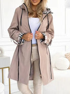 Women's waterproof trench coat featuring a hood and stylish plaid lining, designed for windproof protection and lightweight comfort in winter weather. 1