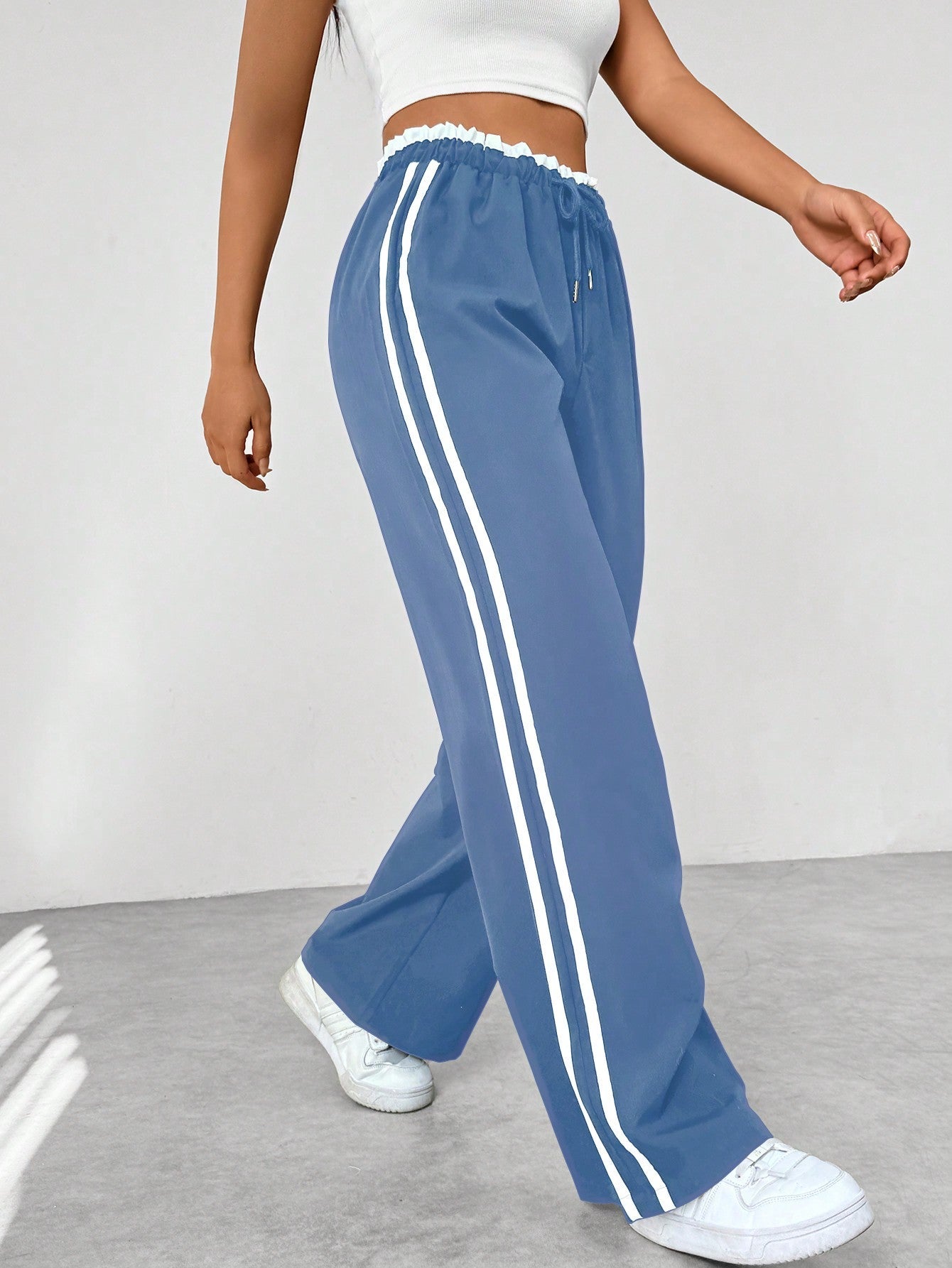 Women's wide leg trousers featuring sporty side stripes, designed for airy comfort and casual style in spring. 1